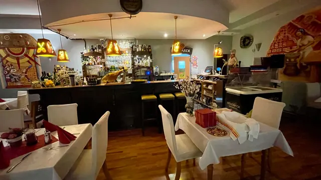 Die Bar mit Barhockern, davor eingedeckte Tische