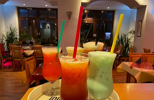 Drei Cocktails im Abendlicht vor dem Gastraum
