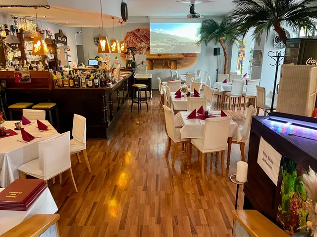 Blick durch den Gastraum zur Bar, Tische mit roten Servietten